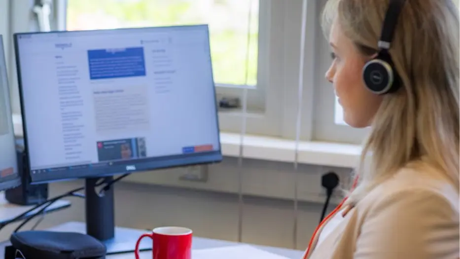 Medewerker met headset beantwoordt vragen achter een scherm met de website van Ikstopnu.nl